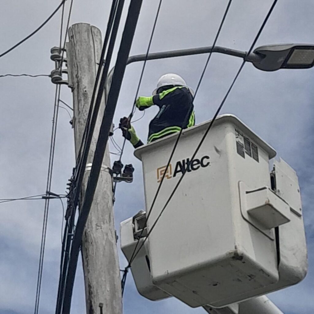 Platinum technician servicing a street light from a bucket truck, Mahaica to Bath Settlement, West Coast Berbice